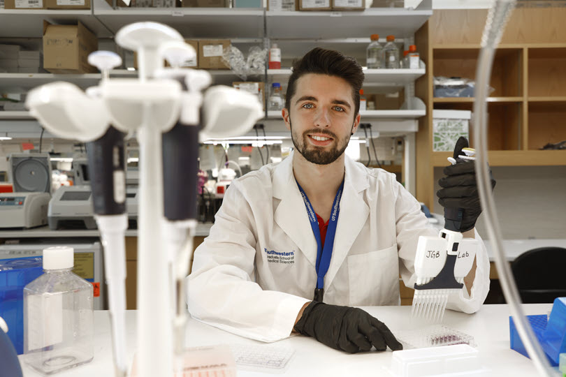 A male student holds a pipette in a lab